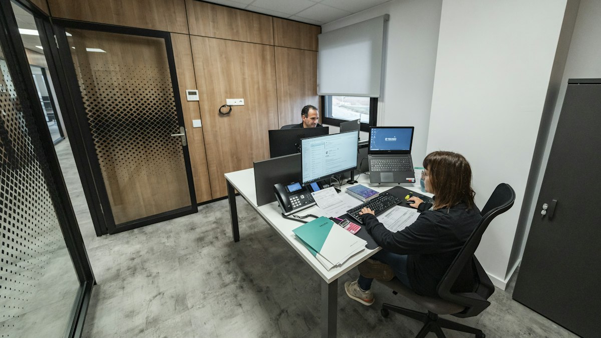 Modern bir ofiste masalarında çalışan kişiler (People working at desks in a modern office)
