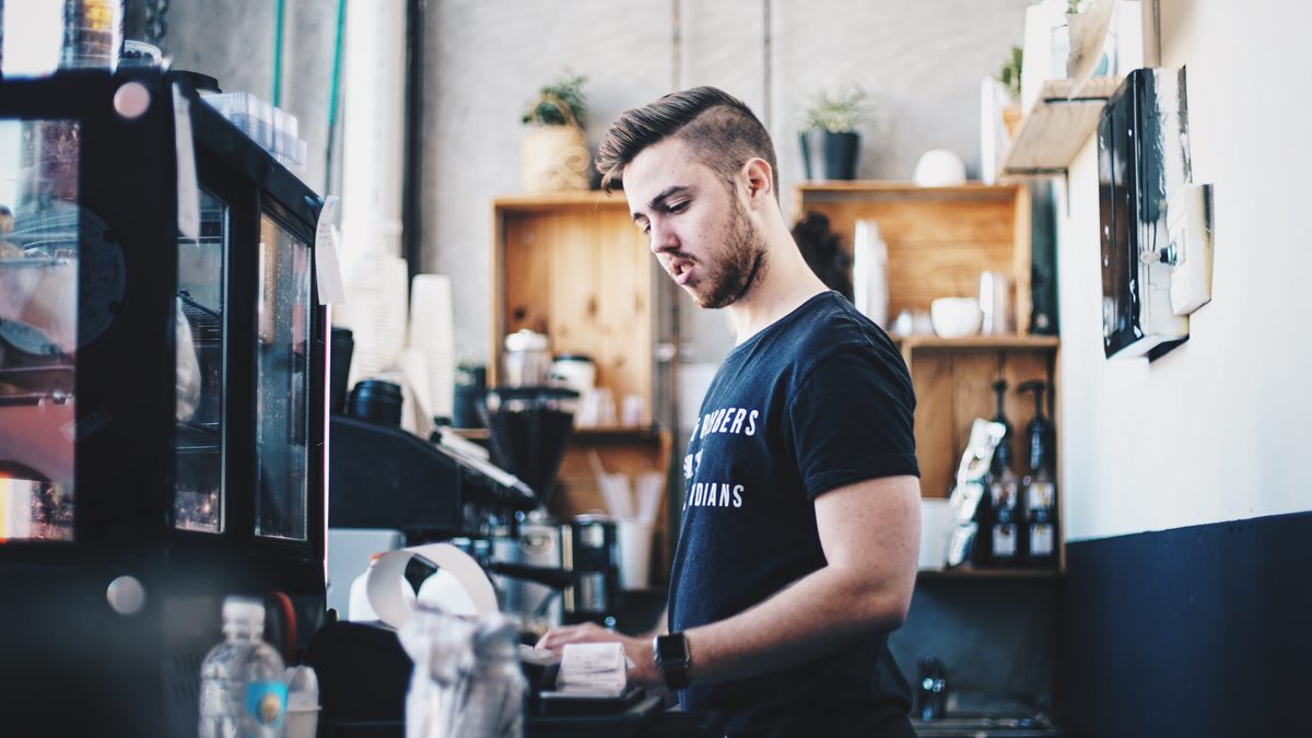 Kafede tezgâhta çalışan barista (Barista working at a cafe counter)