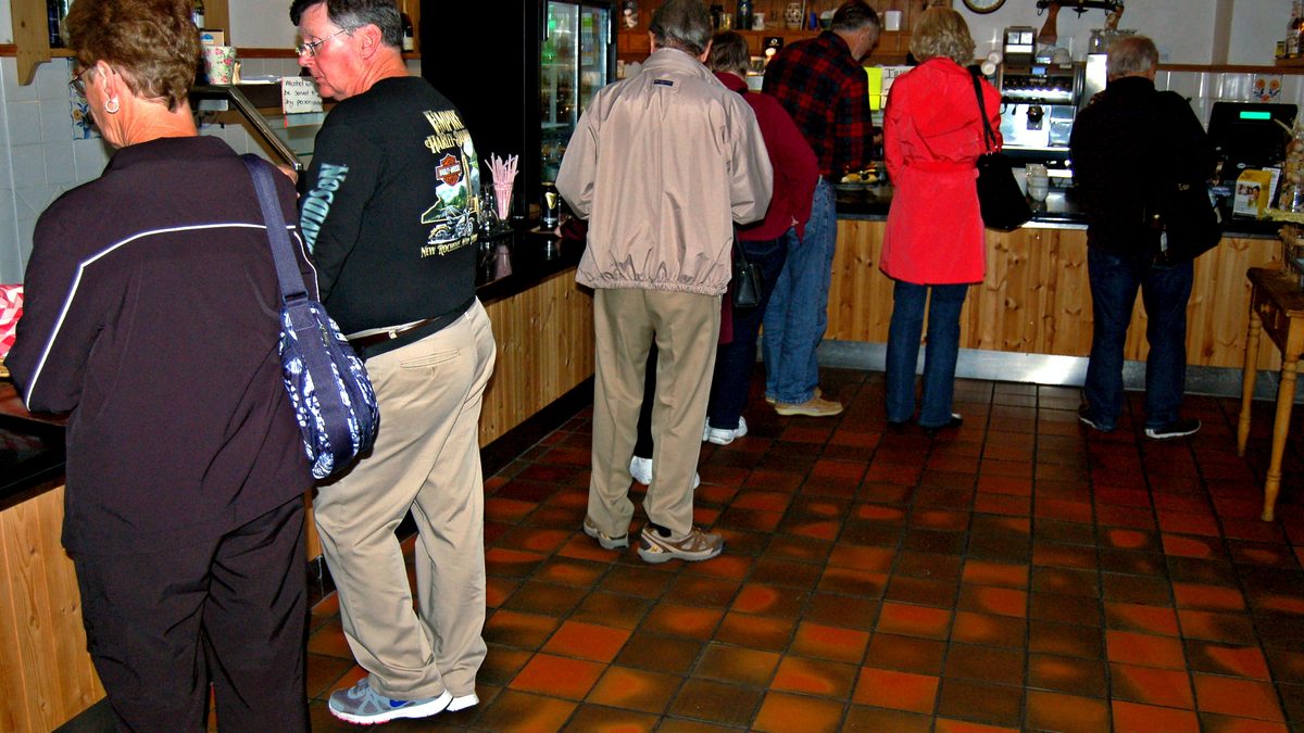 Kafede tezgâhta ödeme sırası bekleyen müşteriler (Customers at a coffee shop counter)