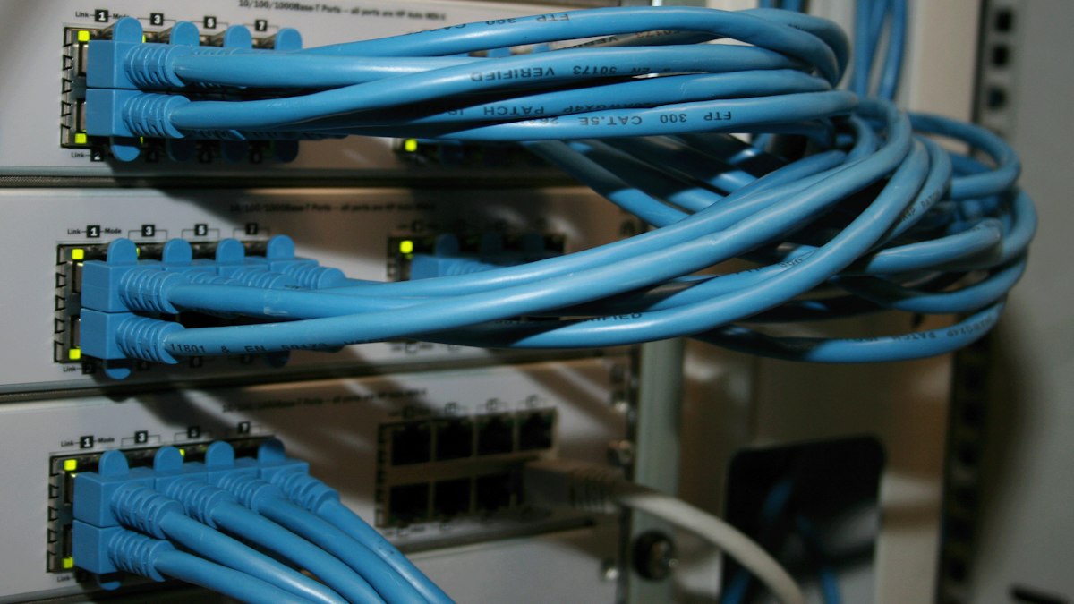 Rack kabinde ağ anahtarı ve kablolar (Network switch and cables in a rack)